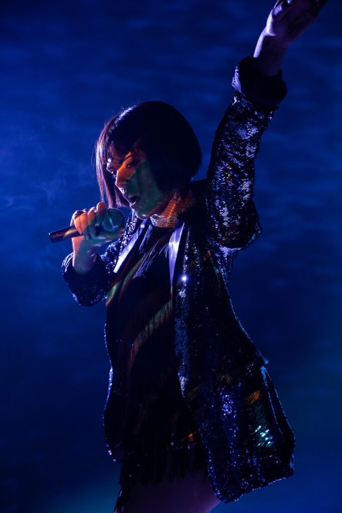 Stylish woman singing on stage